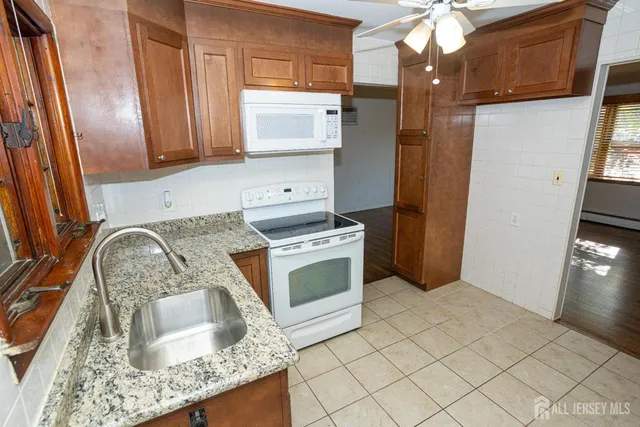 a kitchen with granite countertop a sink stove and refrigerator