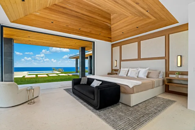 a spacious bedroom with a large window and a table