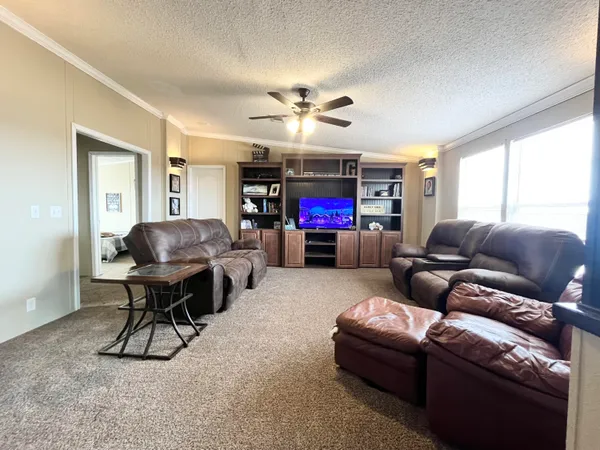 a living room with furniture a flat screen tv and a window