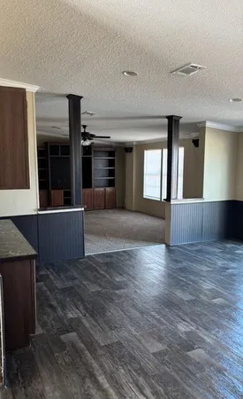 a view of a big room with wooden floor and windows