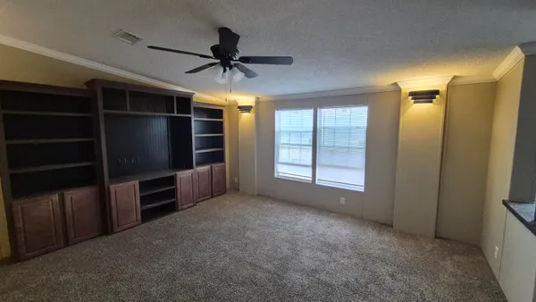 a view of an empty room with a cabinet and a window