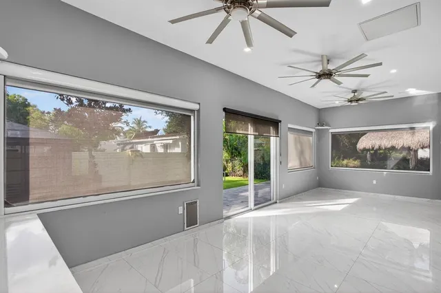 a view of a hallway with a chandelier fan and windows