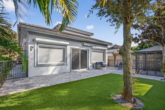 a view of a backyard with a barbeque grill and a large tree