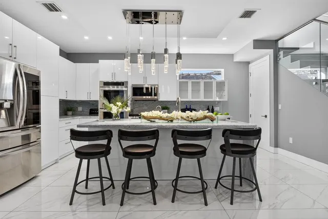a kitchen with stainless steel appliances kitchen island granite countertop a sink and cabinets