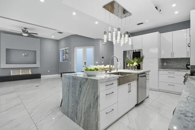 a large kitchen with kitchen island a sink stainless steel appliances and cabinets