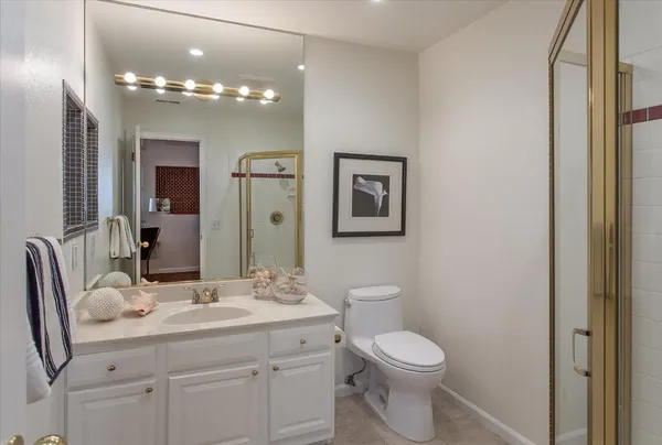 a bathroom with a toilet a sink a mirror a vanity and vanity