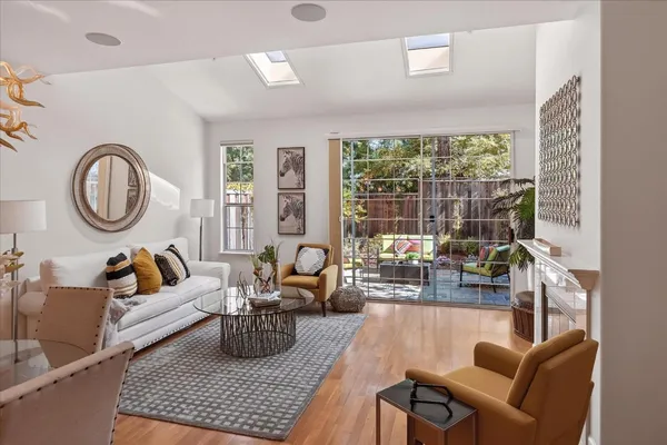 a living room with furniture a table and a large window