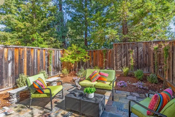 a backyard of a house with seating space and wooden fence