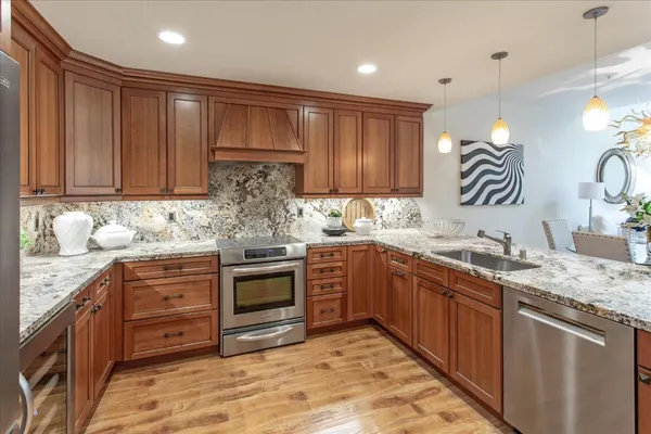 a kitchen with kitchen island granite countertop a sink stainless steel appliances and cabinets