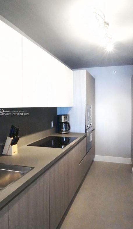 100 Lincoln Road, Unit 426 Miami Beach, FL 33139 - Photo 8 of 8 a kitchen with stainless steel appliances granite countertop a sink and a stove