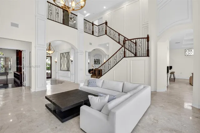 a living room with furniture a fireplace and a chandelier