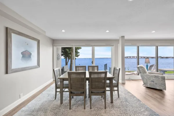 a view of a dining room with furniture large windows and wooden floor
