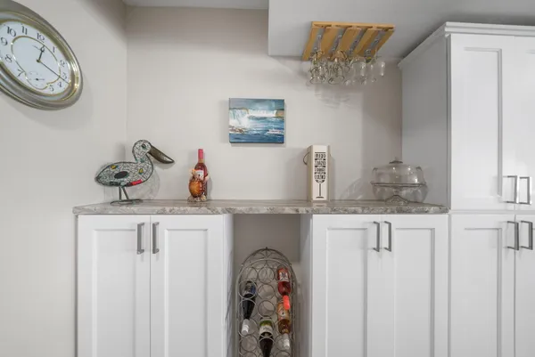 a bathroom with a granite countertop sink a mirror and clock on the wall