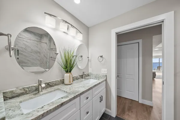 a bathroom with a granite countertop sink a mirror and vanity
