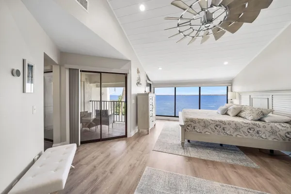 a bedroom with a large bed and a chandelier