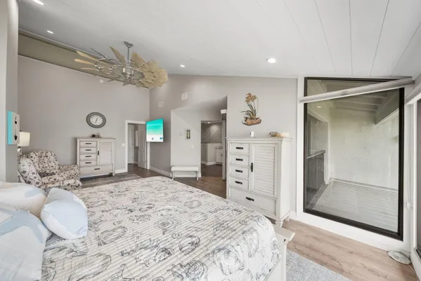 a bedroom with a bed chandelier and a window