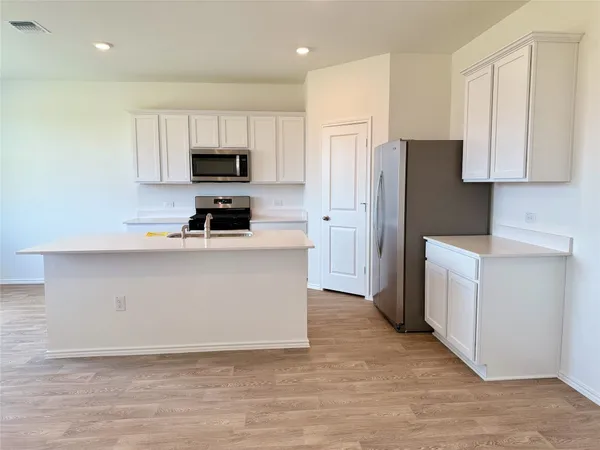 a kitchen with cabinets and stainless steel appliances