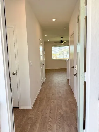 a view of a hallway with wooden floor and windows