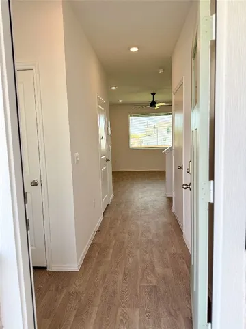 a view of a hallway with wooden floor and windows