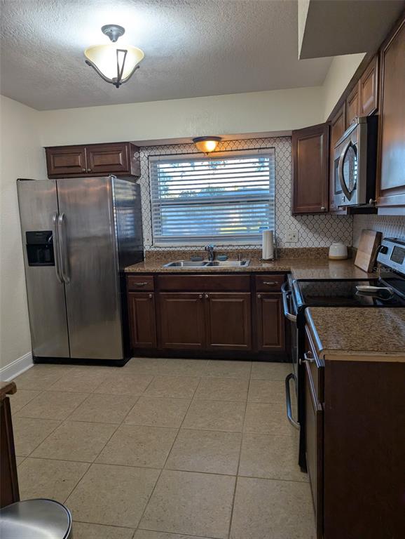 1460 Ruth Road Dunedin, FL 34698 - Photo 14 of 27 a kitchen with stainless steel appliances granite countertop a sink and a stove