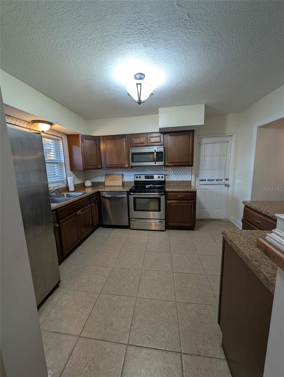 1460 Ruth Road Dunedin, FL 34698 - Photo 2 of 27 a kitchen with stainless steel appliances granite countertop a sink stove and refrigerator