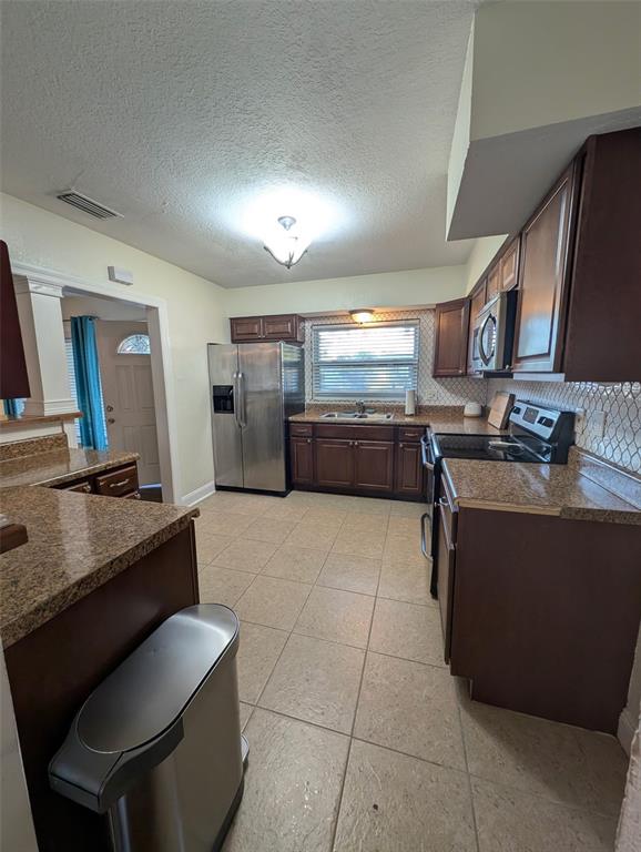 1460 Ruth Road Dunedin, FL 34698 - Photo 4 of 27 a kitchen with stainless steel appliances granite countertop a sink stove and refrigerator
