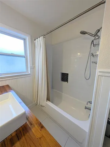 a bathroom with a tub a sink and a shower