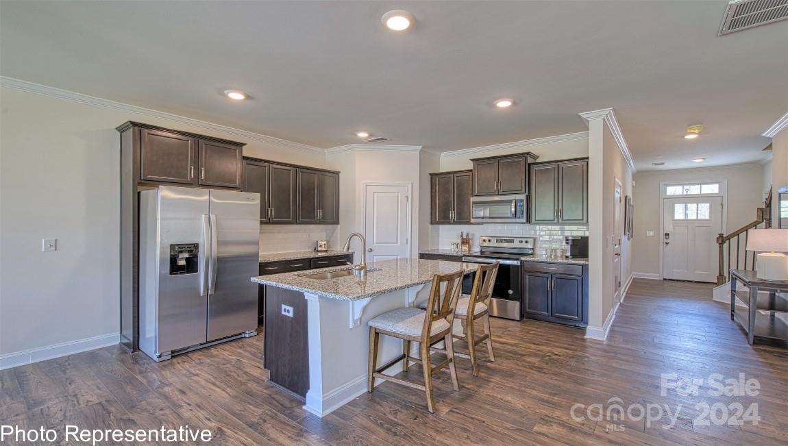 538 Wheatfield Road Fletcher, NC 28732 - Photo 11 of 44 a kitchen with stainless steel appliances kitchen island granite countertop a refrigerator a stove top oven a sink dishwasher and white cabinets with wooden floor