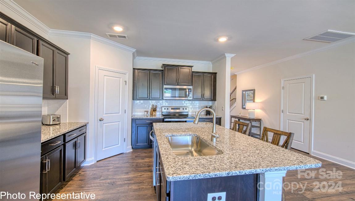 538 Wheatfield Road Fletcher, NC 28732 - Photo 13 of 44 a kitchen with kitchen island granite countertop a stove top oven a sink a counter space and cabinets