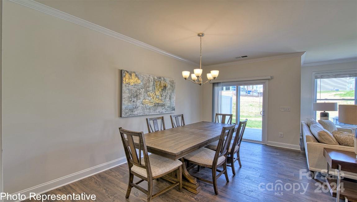 538 Wheatfield Road Fletcher, NC 28732 - Photo 22 of 44 a view of a dining room with furniture a chandelier and wooden floor