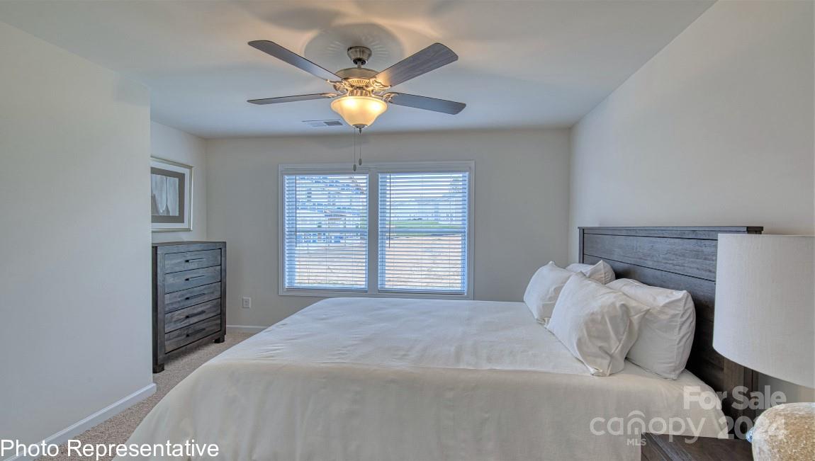 538 Wheatfield Road Fletcher, NC 28732 - Photo 27 of 44 a bedroom with a bed and a chandelier