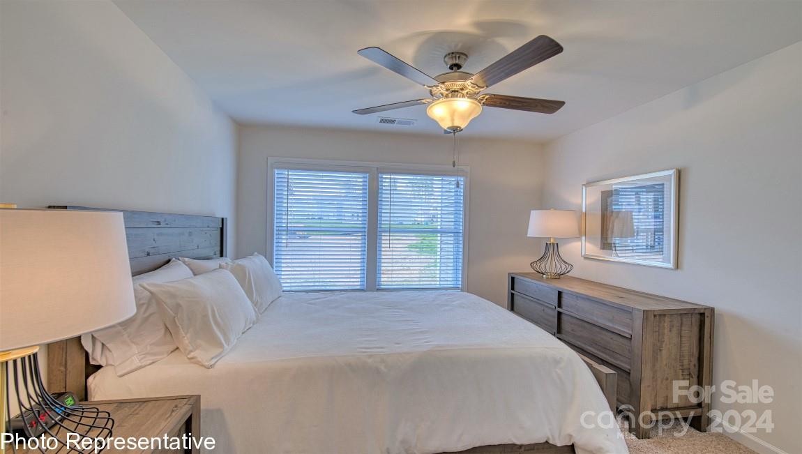538 Wheatfield Road Fletcher, NC 28732 - Photo 34 of 44 a bedroom with a bed and a chandelier