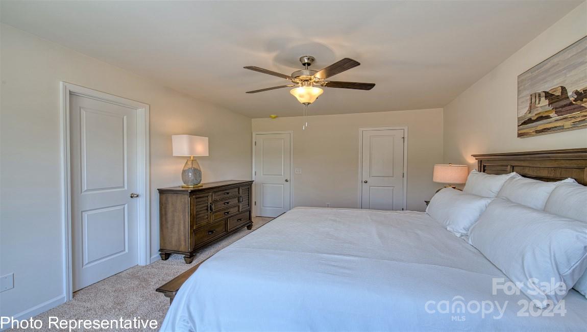 538 Wheatfield Road Fletcher, NC 28732 - Photo 40 of 44 a bedroom with a bed and a chandelier