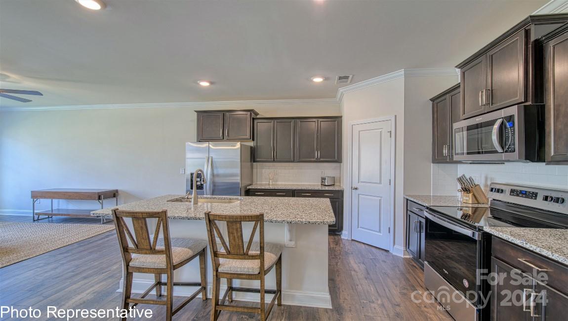538 Wheatfield Road Fletcher, NC 28732 - Photo 9 of 44 a kitchen with a table chairs microwave and refrigerator