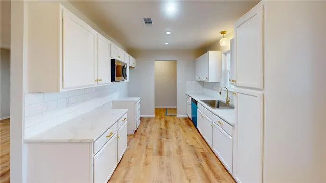 a view of a kitchen with a sink and wooden floor