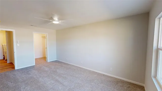 an empty room with an entryway and fan