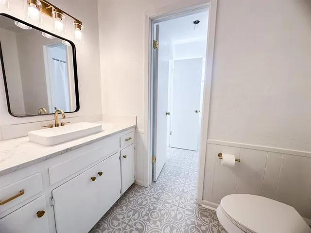 a bathroom with a double vanity sink toilet and mirror