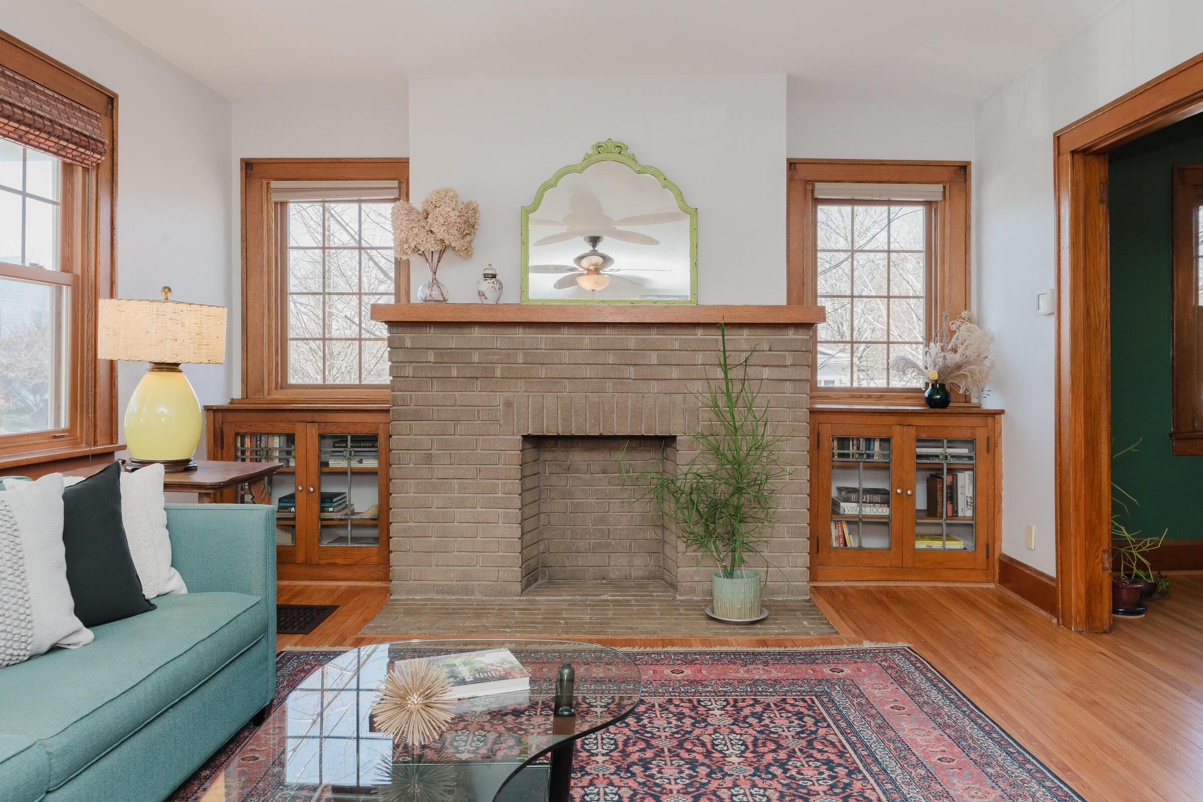 278 Crestview Road Columbus, OH 43202 - Photo 9 of 50 A decorative brick fireplace with mantel is flanked by beautiful built-ins with leaded glass doors.