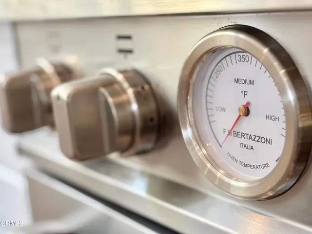 a kitchen with a refrigerator a sink dishwasher stove and wooden cabinets
