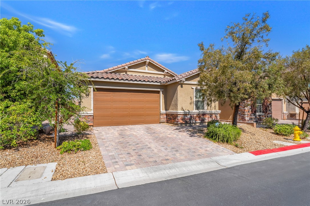 6245 Andover Wood Road Las Vegas, NV 89113 - Photo 1 of 37 A terracotta-tiled roof crowns this residence, featuring a paved driveway and desert landscaping.
