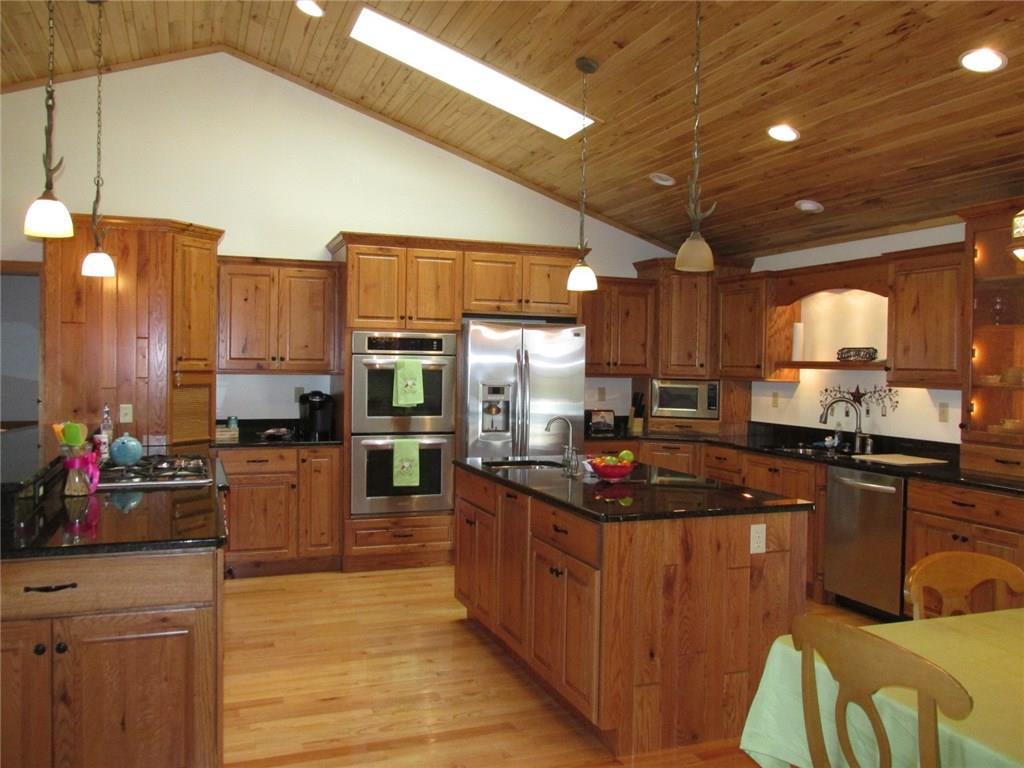 243 Baer Ridge Road Somerset, PA 15501 - Photo 4 of 25 It is a grand kitchen! Ubatuba granite counter tops and back splash. You can see there are two sink areas, one by the dishwasher, and a vegetable sink in the island. Cupboards and drawers galore! How about the skylight! The stainless appliances are all included, note the double electric ovens and gas stove on the left!
