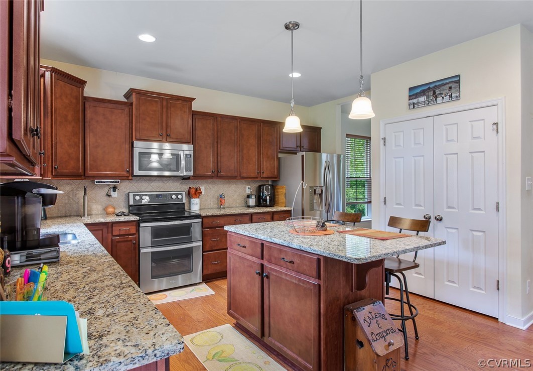 12011 Winterpock Road Chesterfield, VA 23838 - Photo 10 of 33 a kitchen with stainless steel appliances granite countertop a stove top oven a sink a stove a dining table and chairs