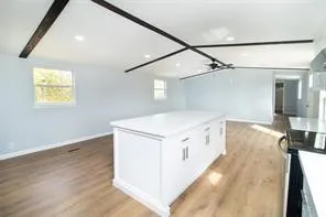 a view of a kitchen with wooden floor and a hallway