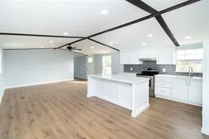 a kitchen with white cabinets and appliances