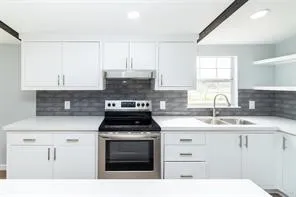 a kitchen with cabinets appliances a sink and a window