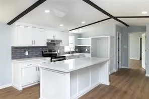 a kitchen with a sink a stove a refrigerator and cabinets