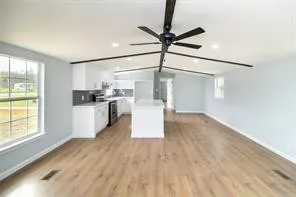 a kitchen with a refrigerator and white cabinets