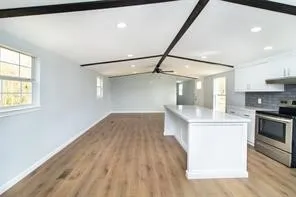 a kitchen with kitchen island white cabinets and black stainless steel appliances
