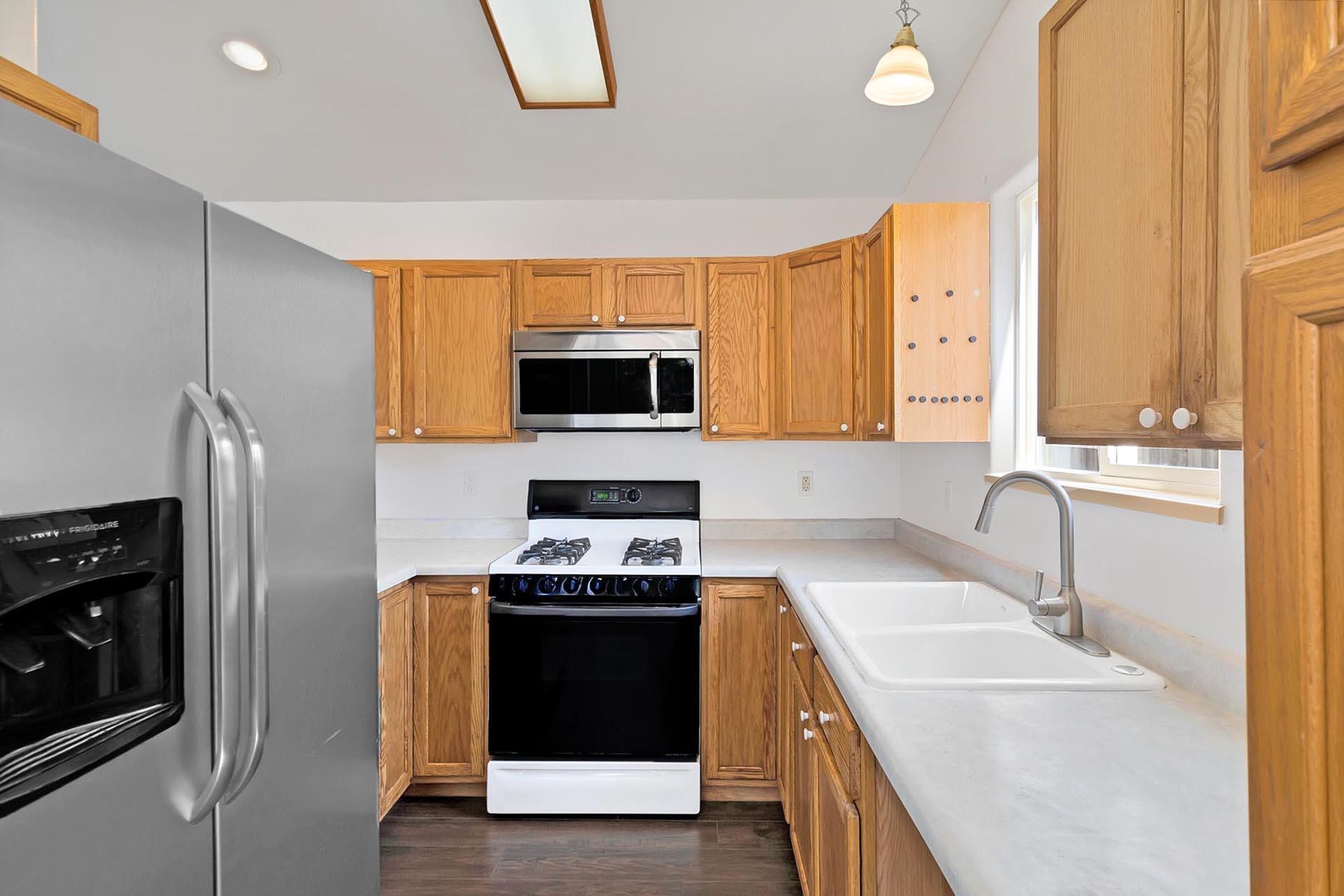 1124 Powell Street Fruita, CO 81521 - Photo 5 of 16 a kitchen with stainless steel appliances granite countertop a sink stove and refrigerator