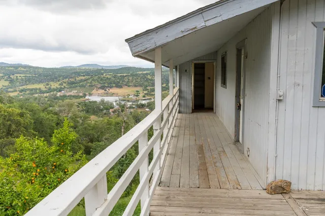 a view of a balcony with wooden floor and fence
